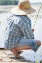 Sitting on wooden bridge barefoot fisherman with Royalty Free Stock Photo