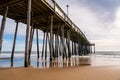 The fishing pier in Ocean City Maryland with sky and pier reflections shown underneath it. Royalty Free Stock Photo