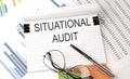 SITUATIONAL AUDIT text on the chart , office supplies, business concept