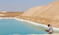 Men in Jalabya in front of The beautiful crystal blue salt lakes in Siwa oasis in Egypt