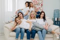 Six beautiful girls on a white sofa