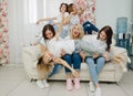 Six beautiful girls on a white sofa