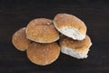 Five Brown Oatmeal Baps or Rolls on a dark wooden oak table