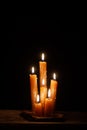 Six burning candles against a black background. Royalty Free Stock Photo