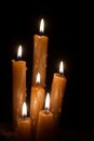 Six burning candles against a black background. Royalty Free Stock Photo