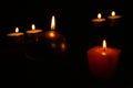 Six burning candles on a black background