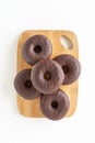 Six chocolate donuts on a wooden board white background with copy space