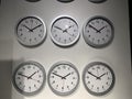 Six clocks on a white indoor wall Royalty Free Stock Photo