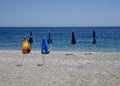 Six closed beach umbrellas on an empty beach