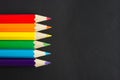 Six colored pencils on a black sheet Royalty Free Stock Photo