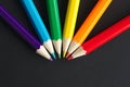 Six colored pencils on a black sheet Royalty Free Stock Photo
