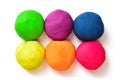 Six colorful balls of modeling clay on a white background