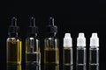 Six containers with aromatic liquids on a black background with reflections Royalty Free Stock Photo