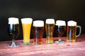 Six different glasses with different types of beer are in a row on a wooden table Royalty Free Stock Photo