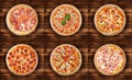 Six different pizza set for menu on the wooden table. Italian food traditional cuisine. Meat pizzas with salami, seafood, ham, p Royalty Free Stock Photo