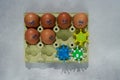 Six eggs on their paperboard watching three toy viruses