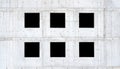 Six empty square windows, black window holes on a grey raw concrete wall, unfinished building side view, detail, frontal, front Royalty Free Stock Photo