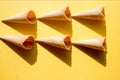 Six empty waffle cups for ice cream on a yellow background in bright sunlight and crisp, hard shadows