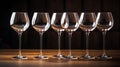 Six empty wine glasses with ligts behind on bar table, AI Generated Royalty Free Stock Photo