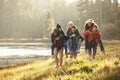 Six friends have fun piggybacking in the countryside by lake Royalty Free Stock Photo