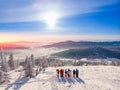 Six friends of skiers and snowboarders are standing on mountain in background of ski resort. Aerial top view Royalty Free Stock Photo