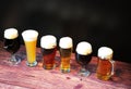 Six glasses with beer of different varieties, stand in a row on a wooden table Royalty Free Stock Photo