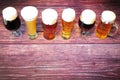 Six glasses of different types of beer are in a row on a wooden table Royalty Free Stock Photo