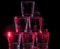 Six glasses stacked by a tower on a multi-colored background Royalty Free Stock Photo
