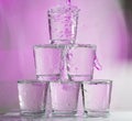 Six glasses stacked by a tower on a multi-colored background Royalty Free Stock Photo