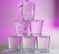 Six glasses stacked by a tower on a multi-colored background Royalty Free Stock Photo
