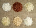 Six heaps of rice of different varieties on the background of sacking Royalty Free Stock Photo