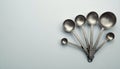 Six Metal Measuring Spoons on Light Blue Surface Royalty Free Stock Photo