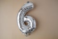6 six metallic balloon on beige neutral background. Greeting card silver foil balloon number Happy birthday holiday