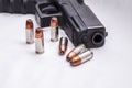 Six 9mm hollow point bullets in front of a black 9mm pistol Royalty Free Stock Photo