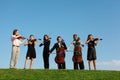 Six musicians play violins against sky Royalty Free Stock Photo