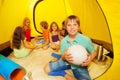 Six nice kids are sitting in a tent
