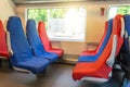 Six passenger seats in red and blue colors inside the high-speed train Royalty Free Stock Photo