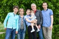 Six people Caucasian family portrait against green tree, elderly grandparents, adult single father, preteen age girl and boy,