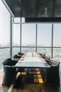 Six people dinner table with plates, knives, forks, wine glasses, glasses and napkins on marble table top with Bangkok cityscape. Royalty Free Stock Photo