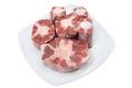Six pieces of raw rabo de toro or bull`s tail isolated on a white square plate on white background