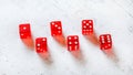 Six red translucent craps dices on white stone like board, showing all numbers from 1 to 6
