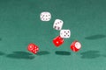 Six red and white dices falling on a green table Royalty Free Stock Photo