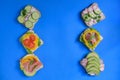 Fresh sandwich with avocado, radish, cucumber, raw ham, pepper and fresh cheese on a blue background, top view Royalty Free Stock Photo