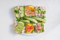 Fresh sandwiches on a plate with rucola and cucumber, ready and healthy snack on a white background Royalty Free Stock Photo