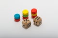 Six-sided dice and circular wooden chips of different colors, red, green, blue, yellow for use in board games such as parcheesi