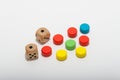 Six-sided dice and circular wooden chips of different colors, red, green, blue, yellow for use in board games such as parcheesi Royalty Free Stock Photo