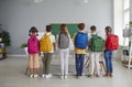 Six small schoolchildren stand in row with large colorful fashionable backpacks on their shoulders. Royalty Free Stock Photo