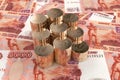 Six stacks of ten-ruble coins folded neatly on five thousand Russian bills