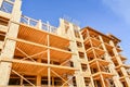 Six storey wooden frame building under construction on blue sky background Royalty Free Stock Photo