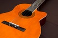 Six-string acoustic guitar on a dark brown background. Classical Spanish guitar. Musical instrument. Place for text Royalty Free Stock Photo